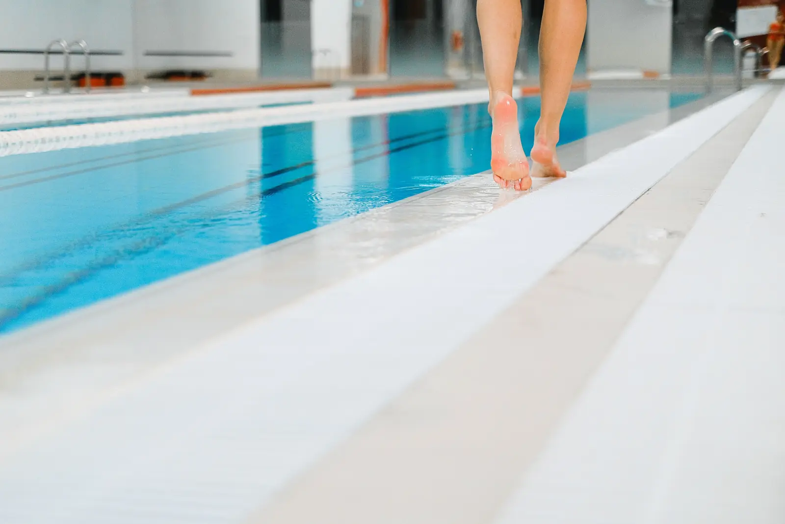 Walking at the edge of an indoor pool